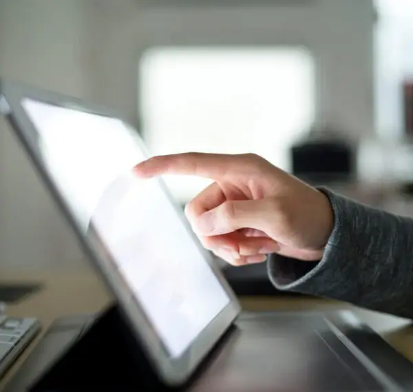 Mano señalando la pantalla de un tablet.